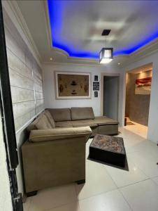een woonkamer met een bank en een blauw plafond bij Casa Completa no Centro in Porto Seguro