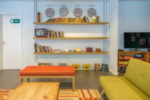 een kamer met banken en planken met klokken aan de muur bij Moon Hill Hostel in Sintra