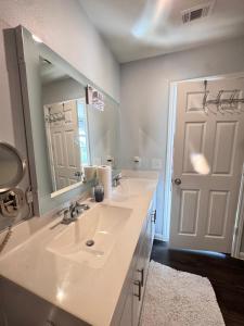 a bathroom with a sink and a mirror and a door at Jeneffer's Home in Houston