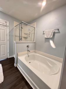 a white bathroom with a tub and a shower at Jeneffer's Home in Houston