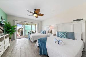 a bedroom with two beds and a ceiling fan at The Sand Dollar at Cottages in Sand Bluff