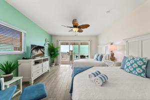ein Schlafzimmer mit zwei Betten und einem Deckenventilator in der Unterkunft The Sand Dollar at Cottages in Sand Bluff