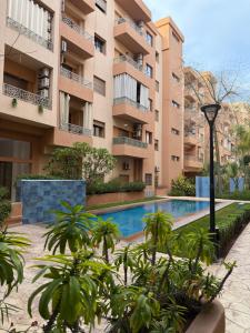 马拉喀什Appartement haut standing的建筑物前的游泳池