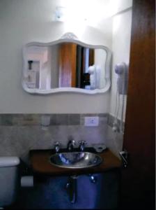 ein Badezimmer mit Waschbecken und Spiegel an der Wand in der Unterkunft Complejo Los Abedules in La Cumbrecita