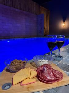 a cutting board with meats and wine glasses on a table at Bangalô Miramar Maragogi in Maragogi