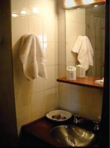 ein Badezimmer mit Waschbecken, Spiegel und Handtüchern in der Unterkunft Complejo Los Abedules in La Cumbrecita