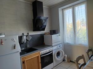 eine Küche mit einem weißen Kühlschrank und einer Waschmaschine in der Unterkunft Soso et Pat in Fourchambault