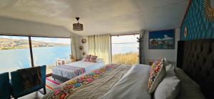 Un dormitorio con dos camas y vista al agua. en Titicaca Floating Lodge, en Puno