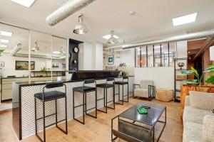 a living room with a bar with stools at Loods - RDC G in Paris +39 photos