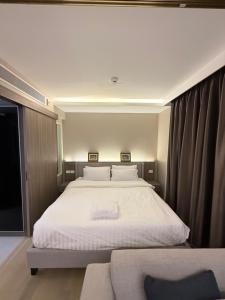 a bedroom with a large white bed and a couch at Cozy room in Sukumvit in Bangkok +5 photos