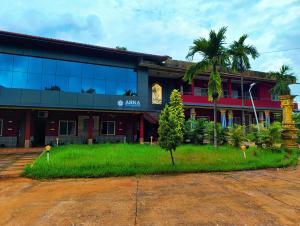 un edificio con una palma di fronte di Kamath regency and cottages marriage Hall a Dharmastala Altre 5 foto