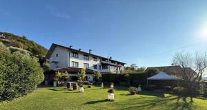 a large white building on top of a lush green yard at Hotel New Genziana in Altavilla Vicentina