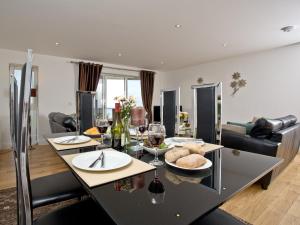 a kitchen and living room with a table with glasses of wine at Fistral View At Bredon Court in Newquay +14 photos