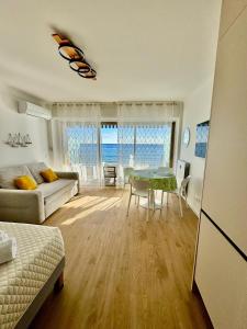 a living room with a table and a couch at Casa Sud Menton vue mer exceptionnelle terrasse parking inclus climatisation in Menton