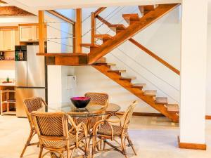 ein Esszimmer mit Tisch und Stühlen und einer Treppe in der Unterkunft Luxo e requinte em um só lugar casa Santo Antônio in Ilhabela