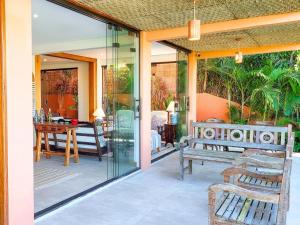 eine Veranda mit einer Bank und einem Tisch auf einer Terrasse in der Unterkunft Luxo e requinte em um só lugar casa Santo Antônio in Ilhabela