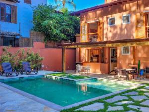 ein Swimmingpool vor einem Haus in der Unterkunft Luxo e requinte em um só lugar casa Santo Antônio in Ilhabela