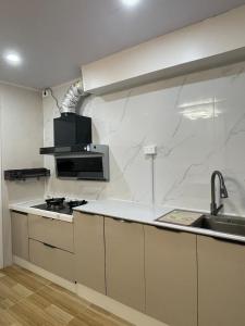 uma cozinha com paredes de mármore branco e um lavatório em Priscilla Apartment家庭公寓两居室 步行到麦当劳 近超市餐厅 免费停车位 em Nadi