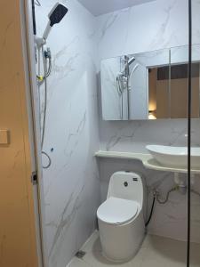 a white bathroom with a toilet and a sink at Priscilla Apartment in Nadi