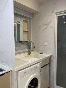 a kitchen with a washing machine and a sink at Priscilla Apartment in Nadi