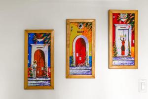 drei Gemälde von Türen an einer weißen Wand in der Unterkunft The No Problem at Cottages in Sand Bluff