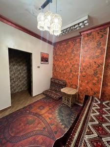 アスワンにあるAswan House centerのオレンジ色の壁とシャンデリアが特徴のリビングルーム