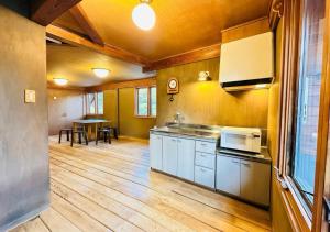 a kitchen with wooden floors and cabinets and a table at The Capsule Hakuba in Hakuba