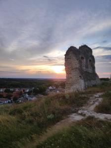 un antiguo edificio en una colina con la puesta de sol en el fondo en Döbrönte MagLak, en Döbrönte 6 fotos más