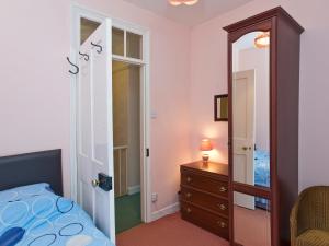 een slaapkamer met een bed, een ladekast en een spiegel bij Bridge End - E1028 in Waxham +7 foto's