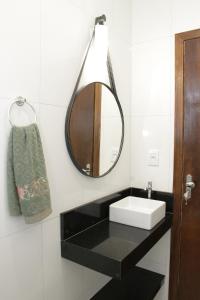 ein Badezimmer mit Waschbecken und Spiegel in der Unterkunft Studio novo com ar condicionado e garagem in São Lourenço + 13 Fotos