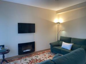 Una sala de estar con un sofá y una chimenea. en Casa do Pereiro, en Vieira do Minho