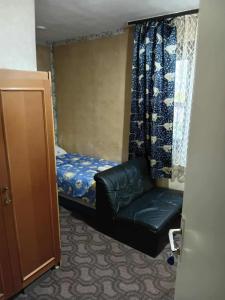 a small room with a bed and a leather chair at KONAK kod ODISEJE 2 in Moševići
