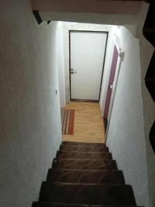 a stairway leading to a white door with a door at KONAK kod ODISEJE 2 in Moševići