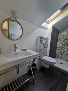 a bathroom with a sink and a toilet and a mirror at Chambre d'hôtes casa di l'apa in Venaco