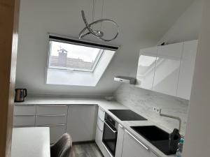 a white kitchen with a window and a sink at Ferienwohnung Steinberg in Dietzenbach