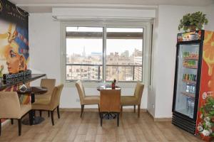 Un comedor con mesa y sillas y una ventana. en Lorenda hotel, en El Cairo