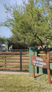 un cartel delante de una valla con un árbol en Casa de Amigos - Moradillo, en Santa Rosa de Calamuchita
