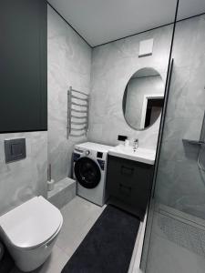 un bagno con lavandino e lavatrice di Затишна квартира в центрі! a Černihiv