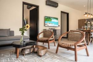 Una sala de estar con dos sillas y un sofá. en 4BDR Luxury Villa 2 Private Pools 10 min Beach & Zamna, en Tulum