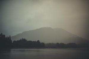 a misty view of a mountain and a lake at NICHT' Apartments Inveraray Town Centre in Inveraray