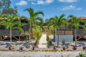 un complejo en la playa con palmeras en Kmar Villas, en Placencia Village