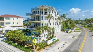 een wit huis met palmbomen voor een straat bij Villa Vista Mare - 675 in Siesta Key