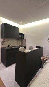 a kitchen with a counter with chairs and a sink at Studio meublé à PNR in Pointe-Noire