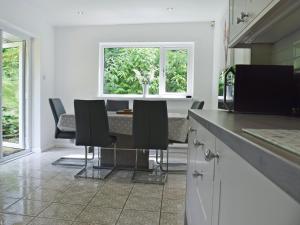 a kitchen with a table with chairs and a window at Manesty in Applethwaite