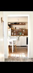 a kitchen with a white table and a white dining room at Villa Linnea in Hanko +14 photos