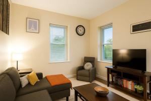 ein Wohnzimmer mit Sofa und Fernseher in der Unterkunft Bright Soulard Loft-King-Queen 2 Baths Parking in Soulard