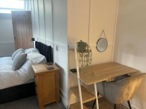a bedroom with a bed and a desk with a mirror at Oak Field View - Self Contained Studio in Scotby