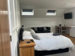 a bedroom with a bed and a table and a chair at Oak Field View - Self Contained Studio in Scotby