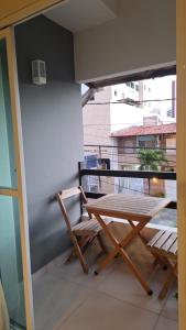 een houten tafel en stoelen op een balkon bij Atalaia mar in Aracaju