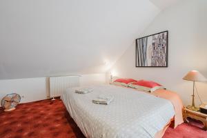 une chambre avec un grand lit blanc avec des oreillers rouges dans l'établissement Maison bonheur proche GIVERNY et top pour télétravail, à Haute-Isle